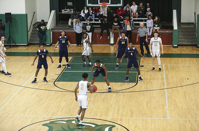 As Holy Spirit Preparatory School guard Miles Wallace (#3) brings the ball up the court during the first half of the Dec. 14 game, the Cristo Rey Atlanta Jesuit High School basketball team sets up in a 3-2 zone on defense. Holy Spirit Prep defeated Cristo Rey Atlanta 77-35. Photo By Michael Alexander