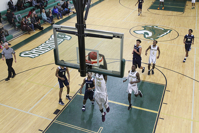 Holy Spirit Prep center Ibrahima Jarjou (#22) dunks the ball as the team pushes the ball up the court during a fast break. Four of Jarjou's seven points in the game came on dunks. Photo By Michael Alexander