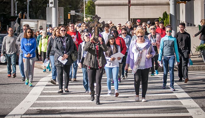 Justice and Peace Ministries sponsored the Urban Way of the Cross March 30 with dozens of pilgrims praying at various city sites to focus on serving others in imitation of Christ. Photo By Thomas Spink