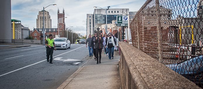 Participants in the annual Good Friday pilgrimage make their way down a city sidewalk after departing the Shrine of the Immaculate Conception in Atlanta. Photo By Thomas Spink