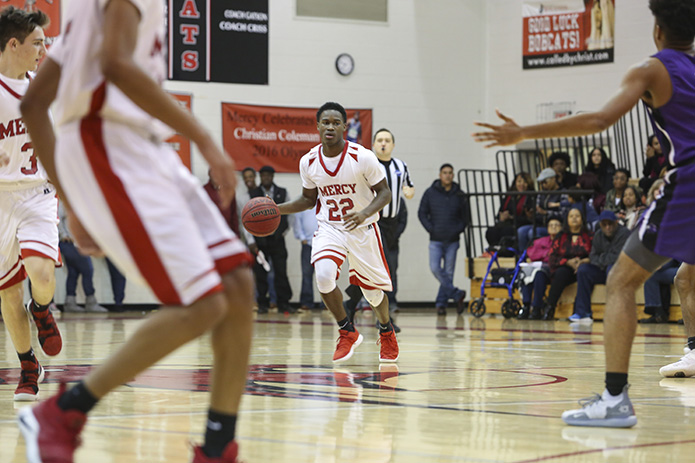 Jais Toles (#22) brings the ball up the court during the second half of Our Lady of Mercy's Feb. 1 game against Trinity Christian School. After trailing by 10 points at halftime, Mercy would close the gap, but the team would still lose its final game of the season 48-41. Photo By Michael Alexander