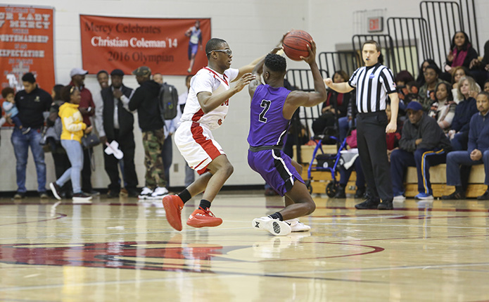 During the closing minutes of the game, Our Lady of Mercy High School junior guard John Wilson, left, plays some tight defense on Trinity Christian guard Tyler Whitfield (#2). Photo By Michael Alexander