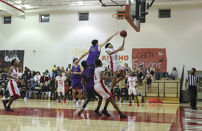 Our Lady of Mercy High School junior Nonso Emefo drives to the basket in the final minute of the Feb. 1 game against Trinity Christian School of Sharpsburg. Emefo had 21 points in the 48-41 loss. Four of his made baskets were from three-point range. Photo By Michael Alexander