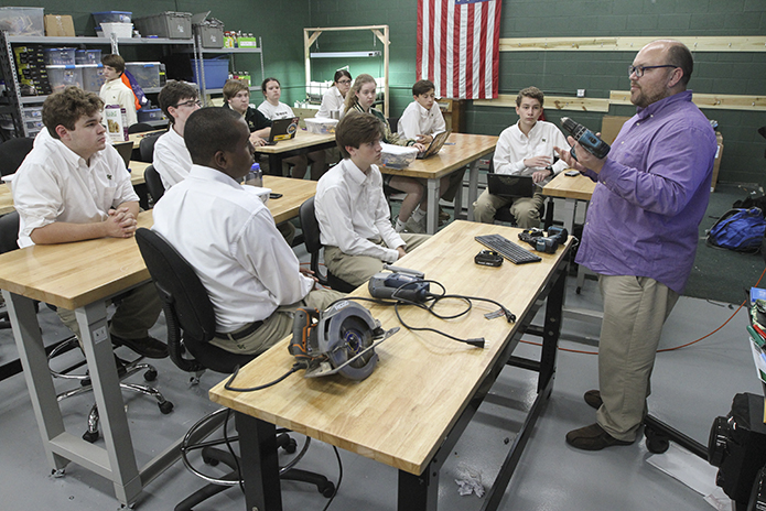 In late September 2018 Dr. Brent Hollers, standing right, conducted a tool and safety training session for Blessed Trinity High School students interested in working on the Roswell school's tiny home project. Hollers is the business and technology education teacher, and he is also one of the project managers for the build. Photo By Michael Alexander