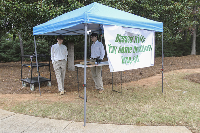 Freshman Matthew Stevens, left, and junior David James hold down the tent where donations could be dropped off last Oct. 25. One of the items dropped off this particular day was silicone sealant. Photo By Michael Alexander