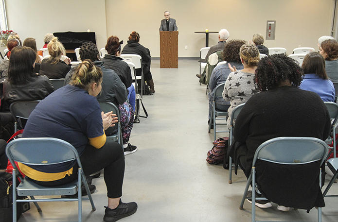 The words of senior priest Father John Kieran, speaking at the podium, are met with applause as he speaks out in support of Sandy Spring's Mary Hall Freedom House and its clients. Father Kieran resides in Sandy Springs. Photo By Michael Alexander