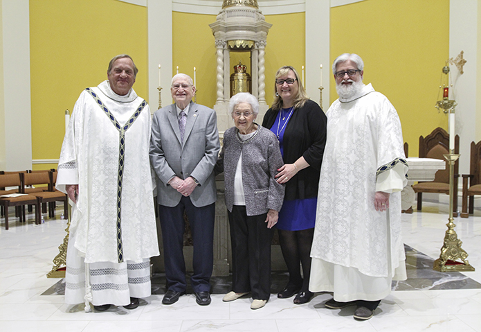 (L-r) Father Francis “Butch” Mazur, the last pastor of St. Gerard Church, Buffalo, New York, Richard and Dorothy Ciezki, their daughter-in-law Frankie, and son Deacon Robb Ciezki of the Diocese of Buffalo pose for photo in front of the altar and tabernacle at Mary Our Queen Church, two of the many artifacts that came from St. Gerard Church when it closed in 2008. Deacon Ciezki served at St. Gerard and his family held membership there at time of its closing. Photo By Michael Alexander