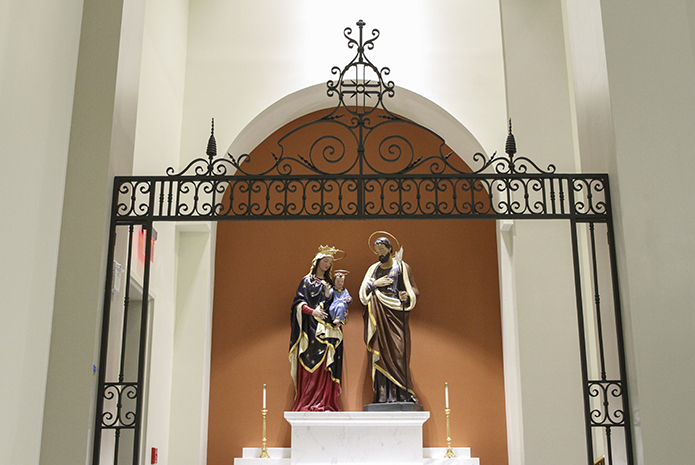 The two statues Mary and Jesus and Joseph appeared on opposite sides of the church in the old Mary Our Queen worship space. In the new church, the Holy Family occupies the same side altar. The iron gates in front of the altar came from St. Gerard Church in Buffalo, New York. Photo By Michael Alexander