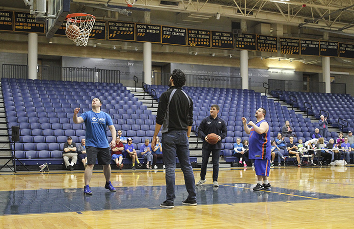 Wearing his University of Florida jersey and trunks, core member Patrick Barlow, right, sinks two of his 36 points from the free throw line during L’Arche Madness, March 23, at Marist School’s Centennial Center. Barlow received a golden basketball award for the most donors on his team. The event raised $46,168 - $16,000 in pledges and $30,000 in matches. Photo By Michael Alexander