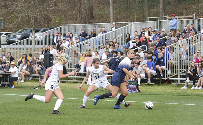 Caroline Ross, right, Marist School forward and the team's leading scorer, advances the ball toward the west end of field as St. Pius X defender Laney Polvino (#17) and midfielder Emmy Glenn (#8) give chase. Photo By Michael Alexander