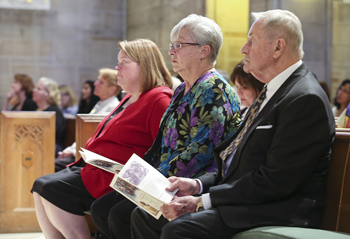 (R-l) Rev. Mr. Bill Keeling of St. Thomas the Aquinas Church, Alpharetta, Lauren Whittaker of Atlanta and Heather Triggs of Holy Spirit Church, Atlanta, sit among the congregation during the responsorial psalm. The trio took the miters, rings and crozier from the bishops before the Penitential Act earlier in the service. Photo By Michael Alexander