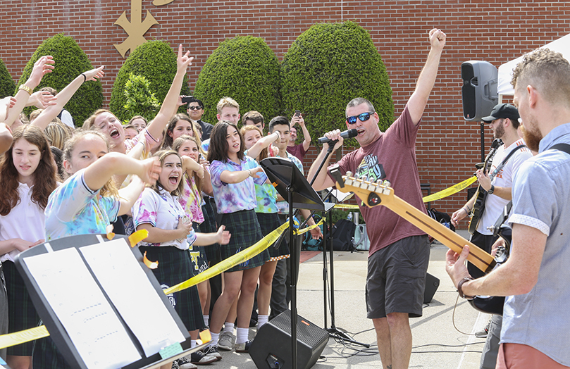 During the fourth period lunch at the May 1 Teacher Jam, St. Pius X High School social studies teacher Scott Carter, third from right, leads the band in a rendition of Queen’s “We Are The Champions.” The band did a medley of Queen songs that also included “Crazy Little Thing,” “Tie Your Mother Down” and “We Will Rock You.” Photo By Michael Alexander