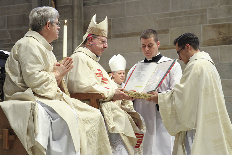 Bishop Joel M. Konzen, SM, presents the Book of Gospels to newly ordained deacon, Rev. Mr. Miller Gómez Ruiz. Photo By Michael Alexander