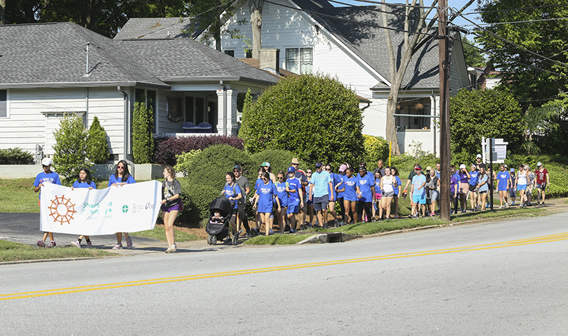 Nearly 60 participants make the five-mile pilgrimage from St. Thomas More Church, Decatur, down East Ponce de Leon Avenue to Refuge Coffee in Clarkston. The purpose of the May 18 walk was to raise awareness about the journey refugees and migrants undertake and to exhibit a public sign of solidarity with them. Photo By Michael Alexander