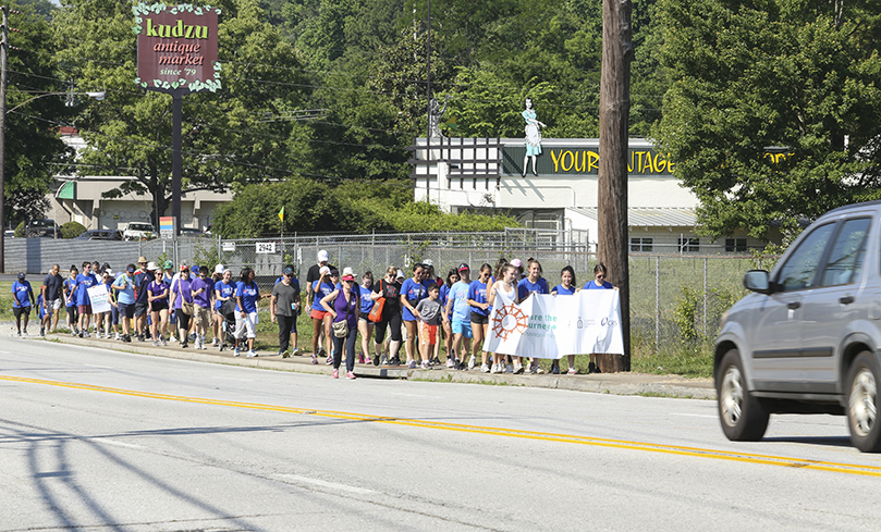 The walkers make their way up East Ponce de Leon Avenue to the Dekalb Farmers Market, the second mile of their five-mile journey. The pilgrimage started at St. Thomas More Church, Decatur, and ended at Refuge Coffee in Clarkston. Photo By Michael Alexander