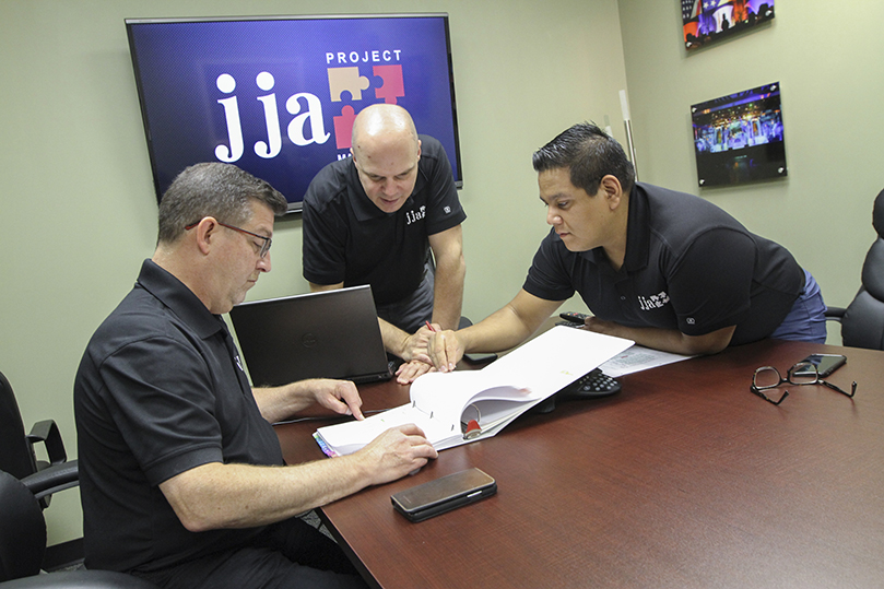 Looking through their Eucharistic Congress binder, JJA Project Managementâs senior staff including (l-r) Joe Andreska, general manager, Gary Seputis, production and technical director, and Ignacio Rivera, social media and digital content coordinator, conduct a pre-production meeting surrounding the 2019 Eucharistic Congress in their Lithia Springs office. The full production meeting will take place 5-7 days prior to the June 21-22 event. Photo By Michael Alexander