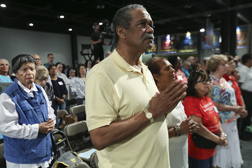 Brian Hendriks and his wife Annmarie of Corpus Christi Church, Stone Mountain, stand for the reading of the Gospel during the opening Mass for the 24th annual Eucharistic Congress at the Georgia International Convention Center, College Park. Photo By Michael Alexander