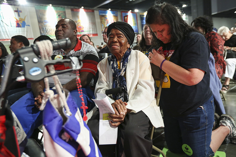 Sts. Peter and Paul Church parishioner Sylfane Jean-Louis, 87, has served as a volunteer usher during the Eucharistic Congress for the past 10 years. After her holy Communion usher duties, she sits in a chair behind her rolling walker with a rosary hanging from it. Photo By Michael Alexander