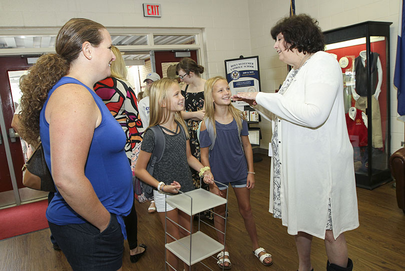 During Holy Redeemer Schoolâs August 5 meet and greet, Kathy Bobar, left, stands by as Holy Redeemer School principal Lauren Schell, right, welcomes back returning students like her twin girls, Brooke and Bailey. The Bobar twins, who have been students at the school since kindergarten, will be sixth-graders this year. Photo By Michael Alexander