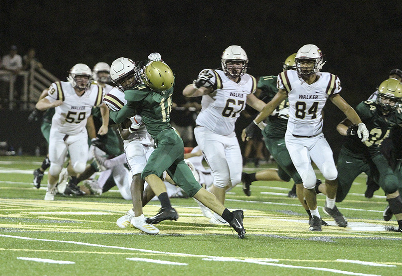 During the third quarter, Pinecrest Academy defensive back Nikitas Missos (#14) led a defensive attack by stopping Walker running back Keon Smart short of the first down on a fourth down play. Photo By Michael Alexander