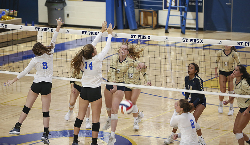 St. Pius X High School middle blocker Maggie McCurdy, center, opposite side of the net, one of five seniors on the team, strikes the ball over the outstretched arms of Mount Paran Christian’s Hannah Pulley (#14) and Beth Bowman (#9). McCurdy had eight kills in the Sept. 24 victory over Mount Paran Christian. Photo By Michael Alexander