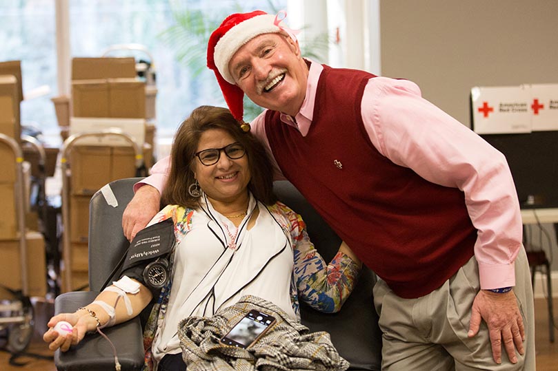 Mark Kelly, right, poses for a photo with a woman as she is donating a unit of blood. Photo By Rob Buechner