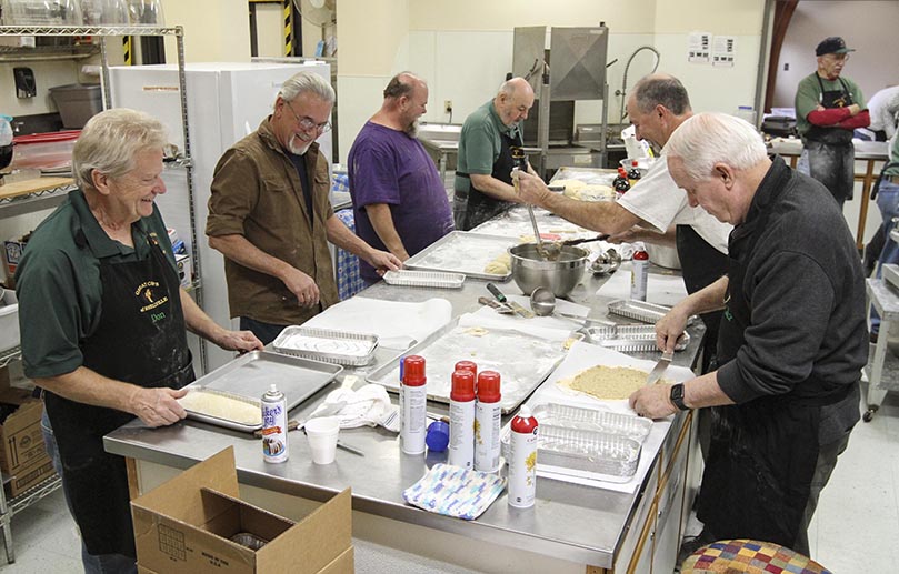 Each member of the St. Oliver Plunkett Church Men’s Club, sometimes referred to as the “The Great Chefs of Snellville,” has fun carrying out a specific role when it comes to the annual preparation of the club’s Polish nut rolls. In addition to cutting, weighing and kneading the dough, there’s spreading the walnut filling over the dough and rolling it up, before it goes into oven. Photo By Michael Alexander