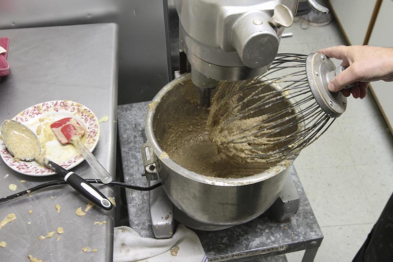 Once the walnut filling has finished mixing, it is poured in another bowl, where it taken over to the table where the men spread it over the dough. Photo By Michael Alexander