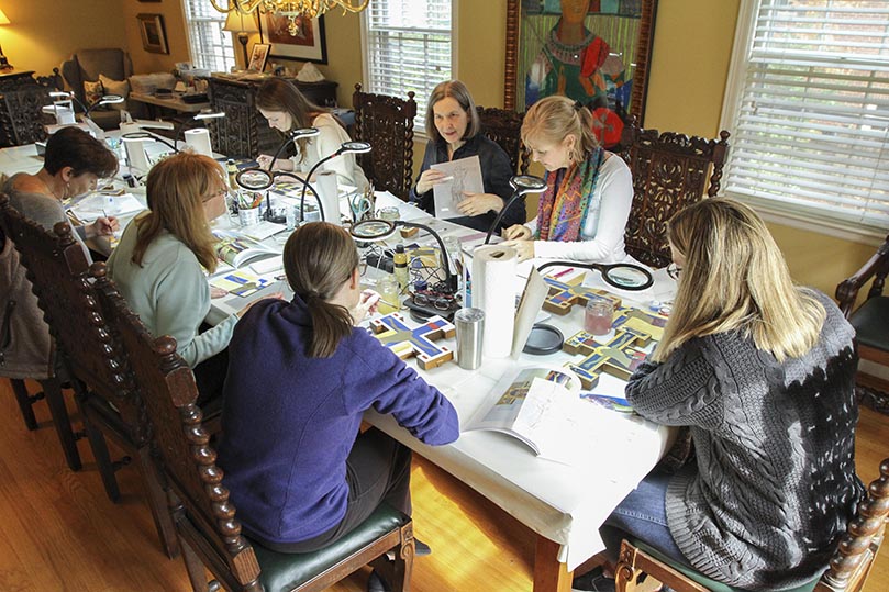 Nancy Ewing holds up a pattern for the crucifix project the afternoon class is working on. The students include (counter-clockwise, from top left) Holy Spirit Church parishioners Rachel Grantham and Mari Hobgood, Cathedral of Christ the King parishioners Lisa Ward and Sallie Forrester, St. Catherine of Siena Church parishioner Helen Young and Cathedral of Christ the King parishioner Gayle Sherlag. Photo By Michael Alexander