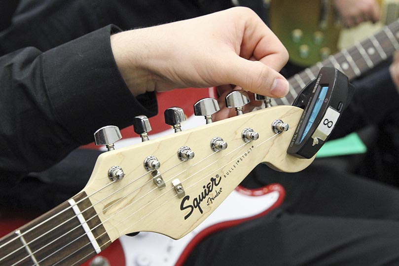 Matthew McDaniel tunes his guitar strings before a Nov. 20 performance last year at Kennesaw State University, Kennesaw. Photo By Michael Alexander