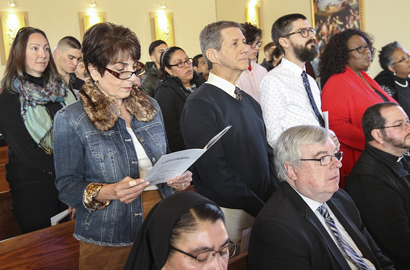 During the presentation of candidates for the Rite of Election and the Call to Continuing Conversion at their parish St. Catherine of Siena Church, Kennesaw, sponsors (second row, standing, l-r) Joanne and Gary Allen stand with candidate Joshua Rystedt. Gary is sponsoring Joshua and Joanne is sponsoring Joshua’s wife, Gabrielle, who was unable to attend. St. Catherine of Siena Church has one catechumen and 29 candidates this year. Photo By Michael Alexander