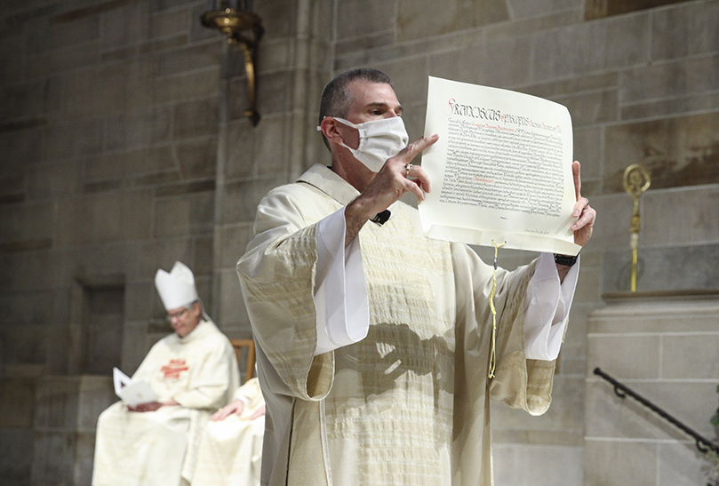 After the Apostolic Mandate is inspected by the College of Consultors, Deacon Thomas McGivney of St. Thomas Aquinas Church, Alpharetta, presents it to the people of the archdiocese for their inspection. The Apostolic Mandate is the decree from the Holy Father that appoints Archbishop Gregory J. Hartmayer, OFM Conv., to the seat of the Archdiocese of Atlanta. Photo By Michael Alexander