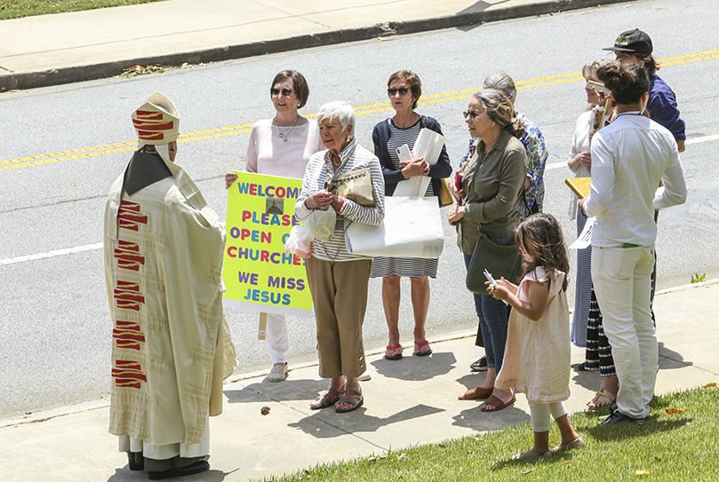 Before his post installation press conference commences, newly installed Archbishop Gregory J. Hartmayer, OFM Conv., walks down to the sidewalk along Peachtree Way, where he had an amicable discussion with a small group of archdiocesan parishioners, who were standing in the distance, expressing their concern for reopening churches during the coronavirus pandemic. Photo By Michael Alexander