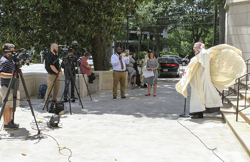 If one of the signs of the Holy Spirit is wind, then maybe the presence of the Holy Spirit was felt by Archbishop Gregory Hartmayer. There was a moment during the press conference when his vestments went flying, and he had to hold on to his zucchetto. Photo By Michael Alexander