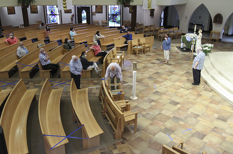 Since the clergy and staff at St. Ann Church, Marietta, will assume responsibility for assisting parishioners during the initial weeks as public Masses resume, they gathered in the church for a May 21 walk-thru of the Mass to rehearse the new guidelines set in place and troubleshoot any potential problems. Photo By Michael Alexander