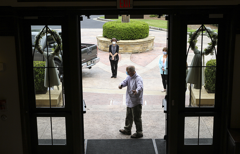 Jim Herrel, foreground, parish administrator at St. Ann Church, Marietta, explains to fellow staff how they will usher parishioners from outdoors to the interior of the church, while maintaining social distancing guidelines. Photo By Michael Alexander