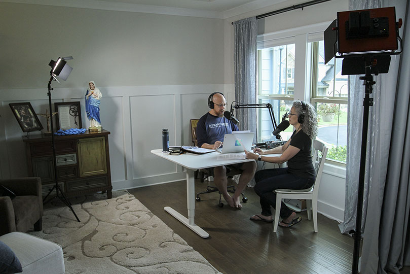 Greg Willits, left, cofounded the Rosary Army with his wife of nearly 25 years, Jennifer, right. Greg serves as the executive director and Jennifer operates as the organization’s CFO (chief financial officer). On this particular evening in early July, the couple was recording episode number 334 of its “Adventures in Imperfect Living” podcast (formerly the Rosary Army Catholic Podcast). Their inaugural podcast was heard in March 2005. Photo By Michael Alexander