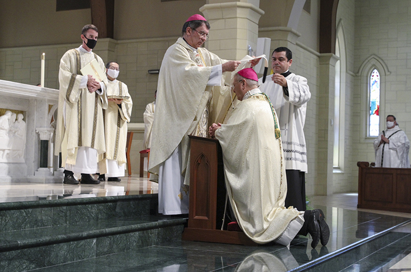 With help from master of ceremonies Father Gerardo Ceballos-Gonzalez, foreground right, Archbishop Chistophe Pierre, foreground left, Apostolic Nuncio to the United States, places the pallium around the neck of Archbishop Gregory J. Hartmayer, OFM Conv., center. The imposition of the pallium took place for the Atlanta archbishop at St. Peter Chanel Church, Roswell, Oct. 7. Photo By Michael Alexander