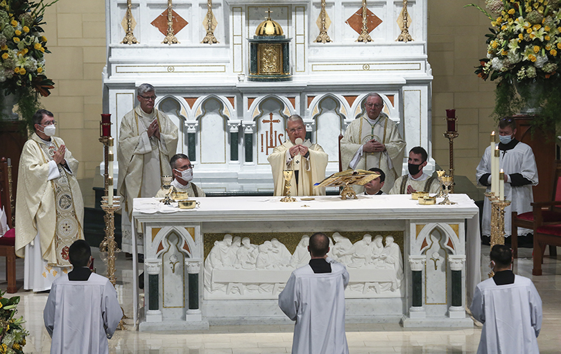 At the Oct. 7 Mass, Archbishop Gregory J. Hartmayer, OFM Conv., center, elevates the host during the consecration. Earlier in the liturgy after the introductory rites, Archbishop Hartmayer was presented with the sacred pallium. Photo By Michael Alexander