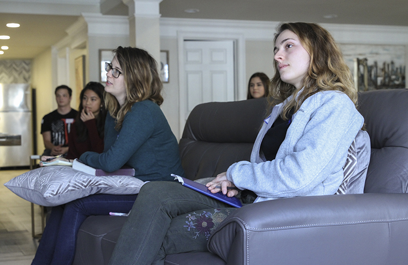 (Sitting on the couch, foreground) Young adults Josie Gregory of St. Brendan the Navigator Church, Cumming, left, and Julia Ross of St. Brigid Church, Johns Creek, listen to the speaker’s talk under the theme, “If you believe, you will see the glory of God.” Photo By Michael Alexander