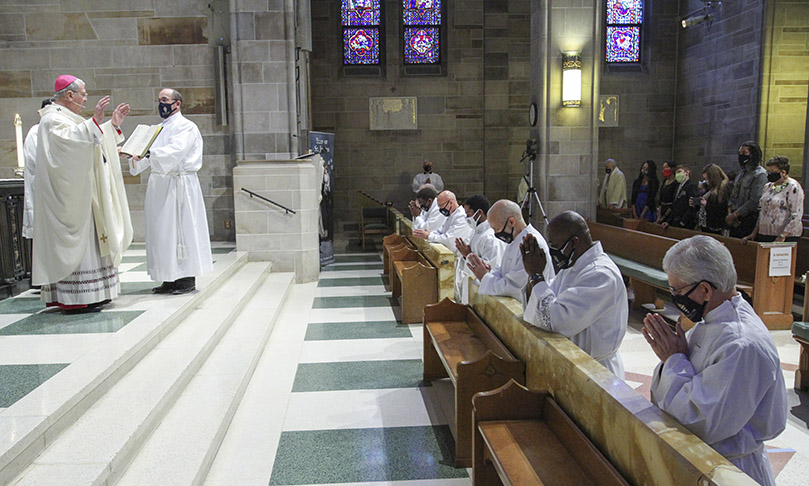 The six permanent diaconate ordination candidates and one transitional diaconate candidate kneel before the altar as Archbishop Gregory J. Hartmayer, OFM Conv., left, conducts the prayer of consecration. At the prayer’s conclusion, the men officially become permanent deacons. The Feb. 6 rite of ordination to the diaconate took place at the Cathedral of Christ the King, Atlanta. Photo By Michael Alexander