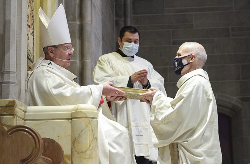 Archbishop Gregory J. Hartmayer, OFM Conv., presents the Book of Gospels to Deacon David Stenzel. Deacon Stenzel is assigned to serve at the Shrine of the Immaculate Conception, Atlanta. Photo By Michael Alexander