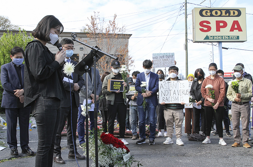 Eunchong Kim, foreground left, a graduate student at Atlanta’s Emory University, was one of the laypeople to lead a prayer during the interfaith prayer service, the afternoon of March 21. Photo By Michael Alexander