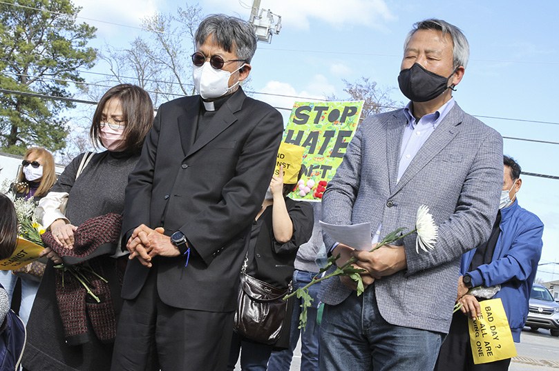 Father Kolbe Chung, foreground left, the administrator of St. Andrew Kim Church, Duluth, and Joseph Nam, foreground right, stand among the crowd during the March 21 interfaith prayer service. Nam, a member of the Korean Martyrs Catholic Church, Doraville, led a prayer during the service that focused on ending Asian hate crimes in America. Photo By Michael Alexander