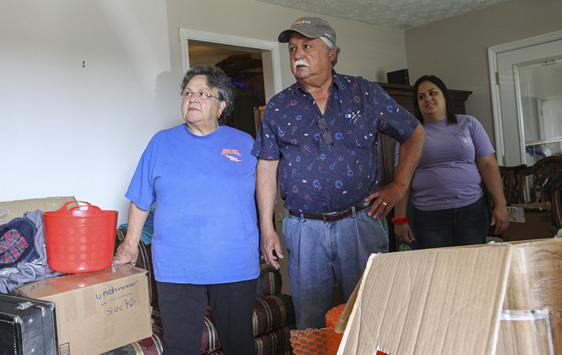 Millie and Alex Garza describe the moments, during the early morning hours, when the EF-4 tornado came through their Newnan neighborhood on March 25. Standing in the background is their youngest daughter, Natalie. The Garza family attend St. George Church in Newnan. Photo By Michael Alexander