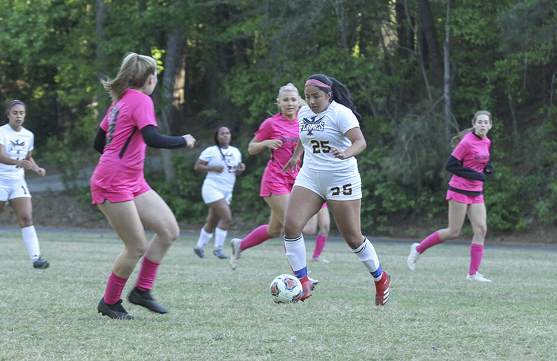 With a look of intensity and concentration, Cristo Rey Atlanta junior Stephany Uballe (#25) attempts to maneuver through the Holy Spirit Preparatory defense. After a 1-1 tie, Uballe scored the go-ahead goal in the second half of the April 21 soccer match to give Cristo Rey Atlanta a 2-1 win. Photo By Michael Alexander