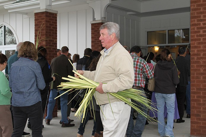 Usher Tom Biehl, center, distributes palms to parishioners as they enter St. Matthew Church, Winder, on Palm Sunday. Photo By Michael Alexander