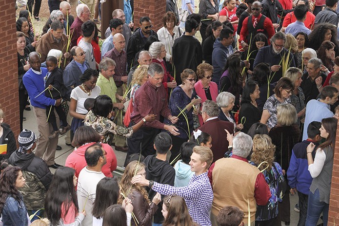 Ushers distribute palms to parishioners as they enter St. Matthew Church, Winder, on March 20, Palm Sunday. Photo By Michael Alexander