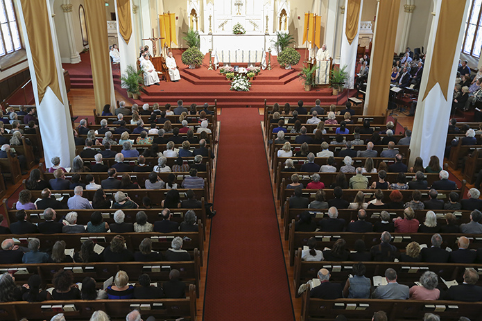 Shrine of the Immaculate Conception pastor Msgr. Henry Gracz, standing at the lectern on the altar, delivers the eulogy during Katie Bashor’s funeral. Some 400 people filled the pews inside the Shrine of the Immaculate Conception, while an overflow crowd watched on closed circuit television at neighboring Central Presbyterian Church, Atlanta. Photo By Michael Alexander