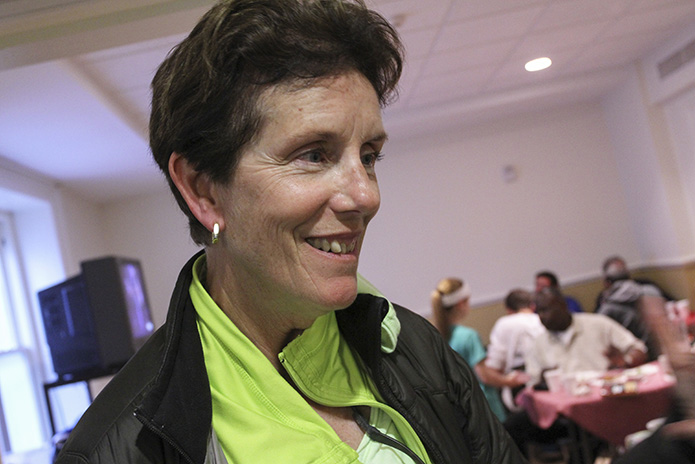 After ensuring things are in order at the Central Night Shelter site in the gymnasium at Central Presbyterian Church, Atlanta, shelter director Katie Bashor stops over at the Shrine of the Immaculate Conception site, where volunteers are serving a meal and mingling with the homeless guests. This took place March 30, 2014. Photo By Michael Alexander